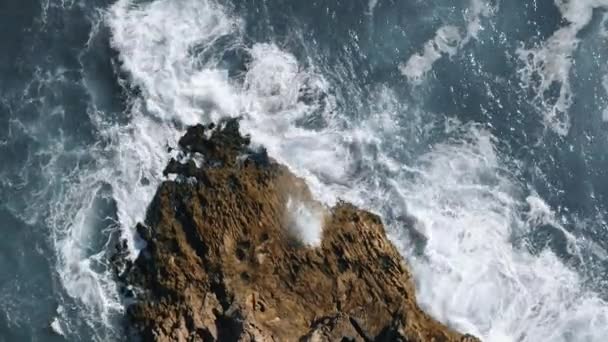 Vagues de l'océan frappé la roche tournante vue aérienne topshot en portugais — Video