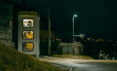 Kız gece telefon kulübesinde konuşuyor. Gizemli ve gizemli bir sokak telefonu