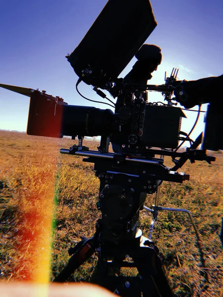 movie camera on a tripod in the field