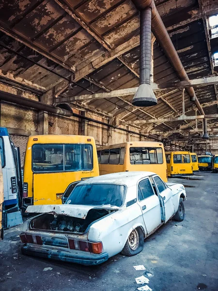 Старый ретро-автомобиль, брошенный между желтыми ржавыми микроавтобусами — стоковое фото