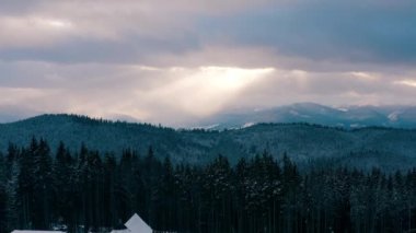 Dağlarda güzel bir gün batımı. Güneş ışınları bulutlar arasında parlıyor.