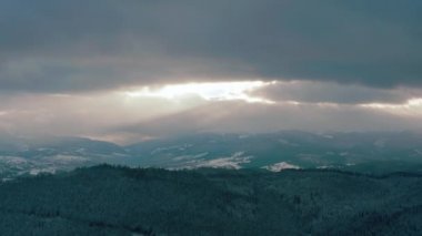 Dağlarda güzel bir gün batımı. Güneş ışınları bulutlar arasında parlıyor.