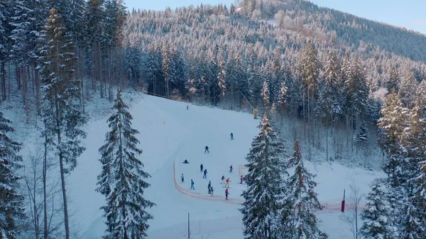 Luftaufnahme von verschneiten Skifahrer und Snowboarder Fahrt auf einer Bergpiste — Stockfoto