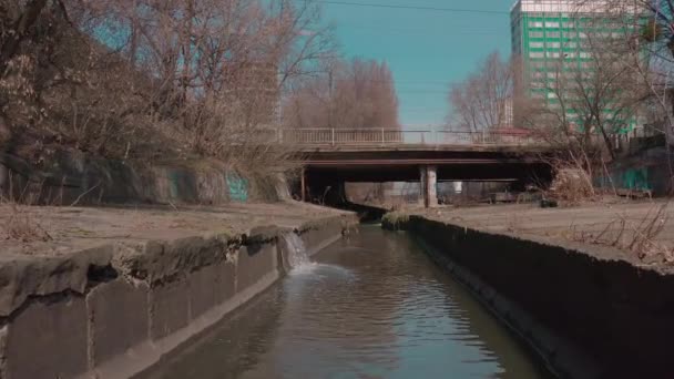 El río, que fluye en un embalse de hormigón en la ciudad. — Vídeo de stock