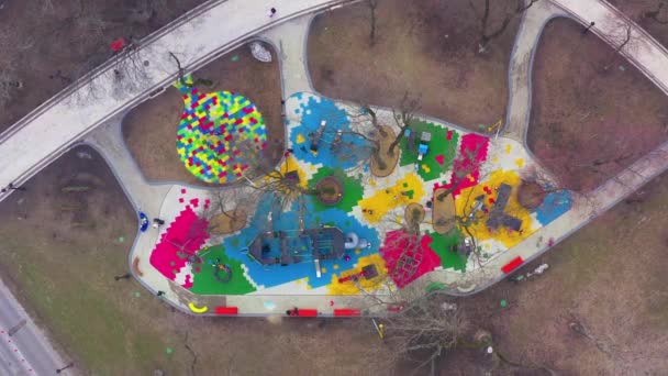 Crianças coloridas fora do parque infantil com carrosséis, balanços e slides — Vídeo de Stock