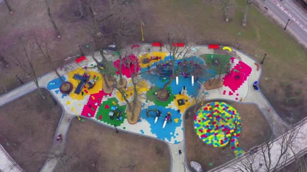 Цветная детская площадка на улице с каруселью, качелями и горками — стоковое видео