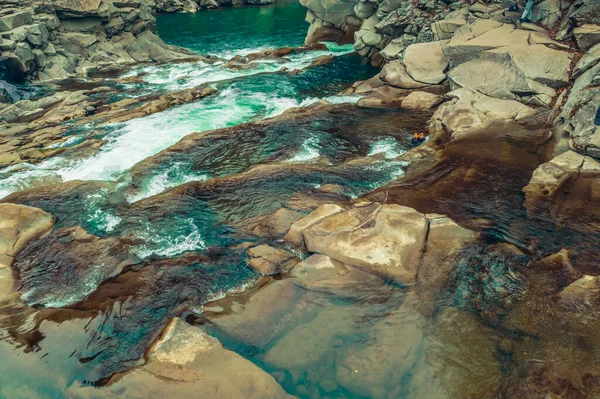 Wasserfall im Winter. Schneller Wasserfluss aus einem Gebirgsbach Stockfoto