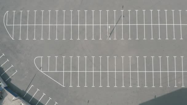 Tiro superior grande estacionamento vazio. asfalto seco dia ensolarado. marcações de linha branca — Vídeo de Stock