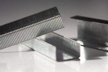 Zımba beyaz arka planda tek sıra halinde duruyor. Üstteki zımba seçici odaklıdır.