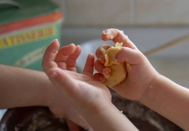 Küçük eller mutfakta hamur yapar. Seçici odak elleri