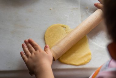 Küçük eller mutfakta hamur yapar. Seçici odak elleri