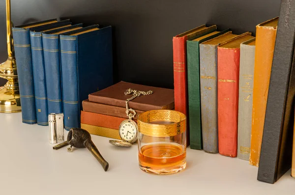 Kitaplar, edebiyat, bilgi kütüphanesi, çakmak, çakmak, tüten pipo ve eski saat. Sherlock Holmes Ofis Masası