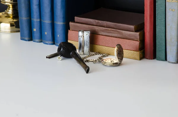 Old library pipe, lighter, pocket watch, books . Sherlock Holmes office desk