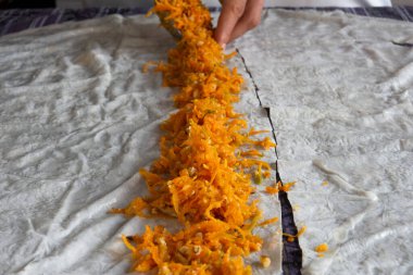 Ev yapımı balkabağı köftesi. Mutfaktaki masada, şekerli kabağı fileto pastasına sarıp pişirmek için hazırlıyorum..