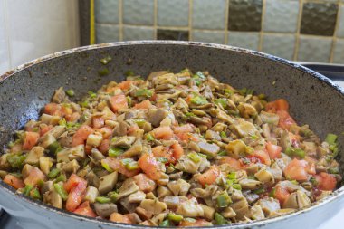 İnce doğranmış istiridye mantarları domates, biber ve baharatla bir tavada pişirilir. İstiridye mantarlı sahte kokore, Pleurotus ostreatus. Chili biberi, kekik, biber, domates,