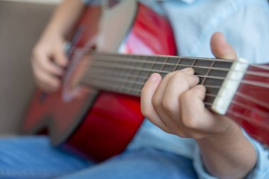 Gitar çalan küçük çocuk. parmakları ve gitar perdelerini kapat