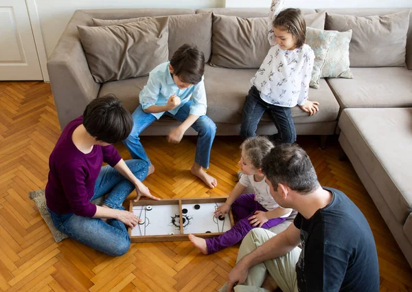 Whole Family playing game. Mother and little girl playing. Sitting on the floor in the middle of the living room playing games with the whole family