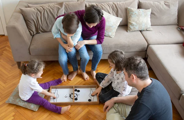 Whole Family playing game. Mother and little girl playing. Sitting on the floor in the middle of the living room playing games with the whole family