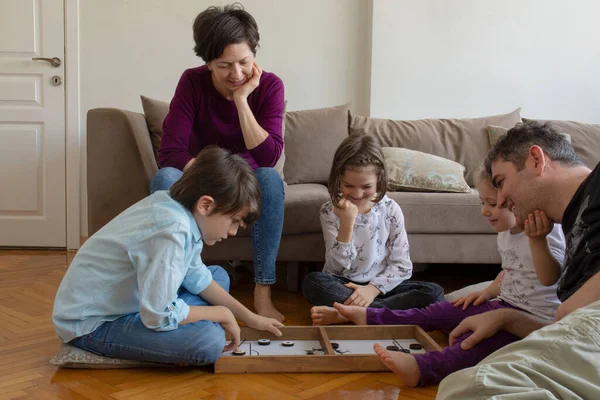 Whole Family playing game. Sitting on the floor in the middle of the living room playing games with the whole family