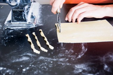 Ahşap bir mazada ev yapımı makarna hazırlıyorum. Geleneksel İtalyan mutfağı kavramı.