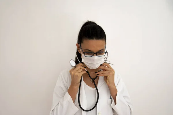 young Female Doctor with Glasses wears a stethoscope. getting ready for the day. Selective Focus Hand and Face.