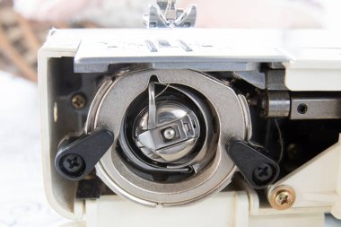 Bobbin Case Beneath The Sewing Machine. shiny parts