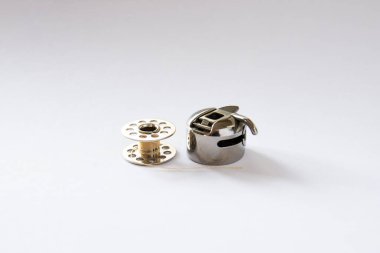 sewing machine   bobbin and bobbin case. white background