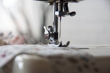 Sewing machine operation from different angles and sewing a flowered fabric. Selective Focus Machine part.