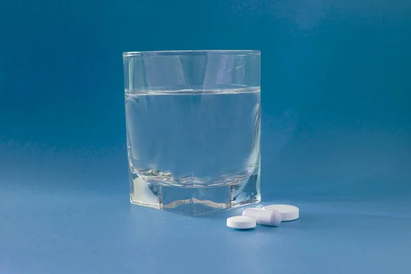 Bicchiere Acqua Medicine Pillole Droghe Isolato Sfondo Blu — Foto Stock