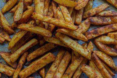 Ev yapımı baharatlı fırında patates ve yağsız kâğıt. seçici odaklı dilimlenmiş patates.