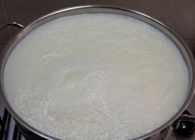 Yoğurt yapmak için önce sütü kaynatırız. seçici odak süt yüzeyi.