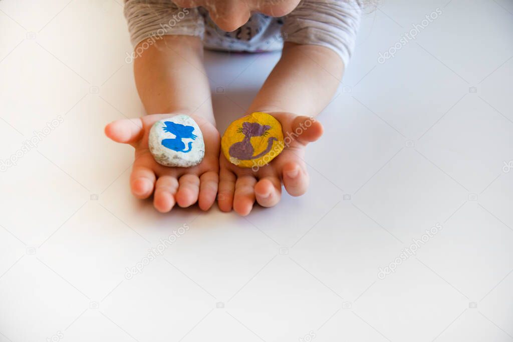 the little girl shows her father the stones that she has painted in color