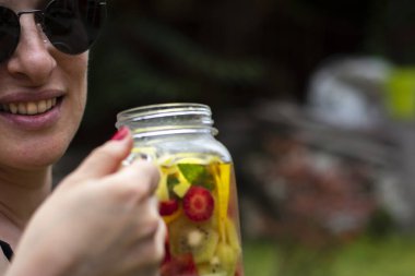 Genç kadınlar, bahçelerinde pilates ya da yoga yaptıktan sonra detoks içeceklerinin keyfini çıkarırlar..