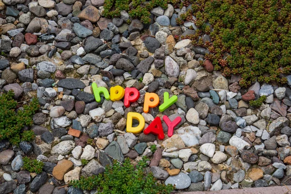 Feliz Dia Lettering Escrito Com Cartas Brinquedo Sobre Pedras Jardim — Fotografia de Stock