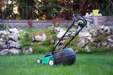 Çimlerin üzerindeki çim biçme makinesi.
