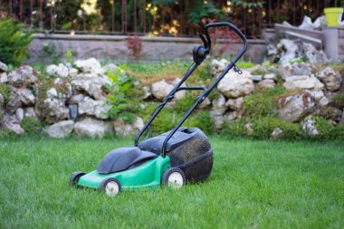 Çimlerin üzerindeki çim biçme makinesi.