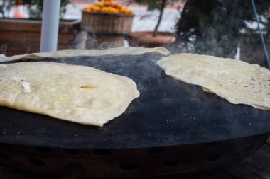 Geleneksel Türk mutfağı, sokak yemekleri: gözleme. Yerli bir kadın, içine peynir, ıspanak ya da patates koyduğu metal tabaka üzerinde krep pişiriyor. Seçici Odaklama Krepleri.