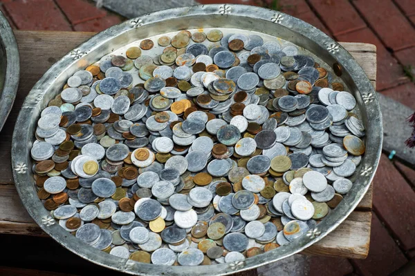 a pile of Turkish coins in an antique copper tray.