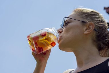 Genç kadın, bahçelerinde pilates ya da yoga yaptıktan sonra detoks içeceklerinin keyfini çıkarıyor..