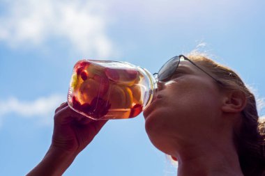 Genç kadın, bahçelerinde pilates ya da yoga yaptıktan sonra detoks içeceklerinin keyfini çıkarıyor..