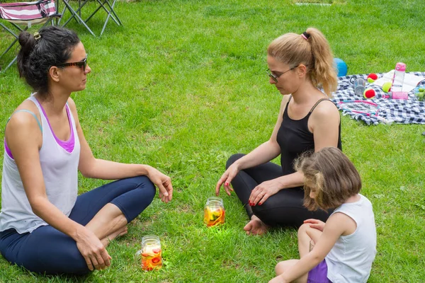 Dos Mujeres Jóvenes Una Niña Jardín Haciendo Yoga Luego Bebiendo — Foto de Stock