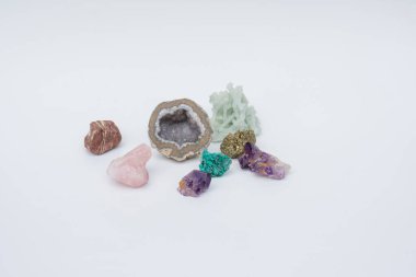 Beyaz arka planda Amethyst, Rose Quartz, Chrysocolla gibi renkli değerli süs taşları. Seçici Odaklanma