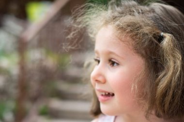 Küçük kız büyük bir gülümsemeyle başka tarafa bakıyor. Seçici Odaklı Kızlar pilici