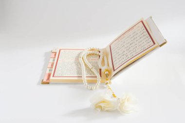 Dua kitabı ve beyaz boncuklu tespih. izole edilmiş beyaz arkaplan