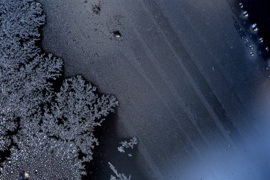 Camdaki buzun görüntüsü. Dışarıdaki sıcaklık sıfırın altında. Güneş ışınlarında, cam üzerinde donmuş su kristalleri. Pencere camında çok güzel buz deseni var. arkaplan olarak metin ya da resim için buz