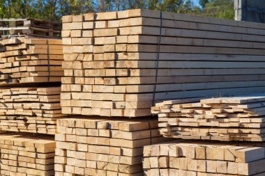 Satılık tahtalar. Kereste deposunda işlenmiş ahşap yığınları. Arkaplan