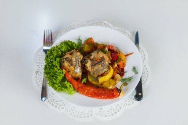 Sebzelerle pişirilmiş deniz balığı. Covid-19 tecridi sırasında evde sağlıklı beslenme yemekleri pişirmek. Bulanık arkaplan ile seçmeli odak.