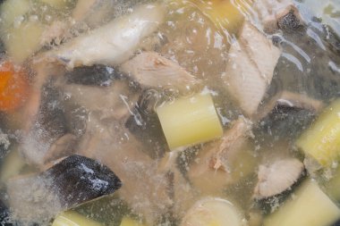 Somon balığı çorbası kaynar suda pişirilir. Seçici odak ve bulanık arkaplan ile mutfak arka planı.