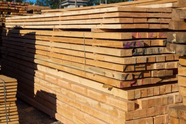 Satılık tahtalar. Kereste deposunda işlenmiş ahşap yığınları. Arkaplan