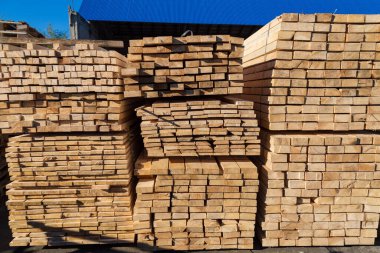 Satılık tahtalar. Kereste deposunda işlenmiş ahşap yığınları. Arkaplan